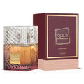 Frasco de cristal tallado con perfume ámbar y base burdeos, junto a su caja burdeos y dorada, de Khamrah Dukhan Eau de Parfum de Lattafa, 100 ml.